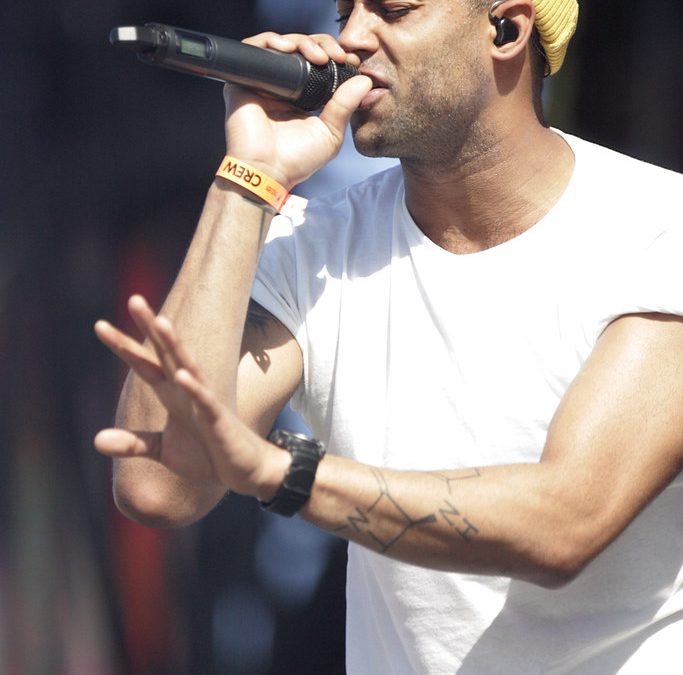 Large sports arena with stage lighting and packed crowd for major event